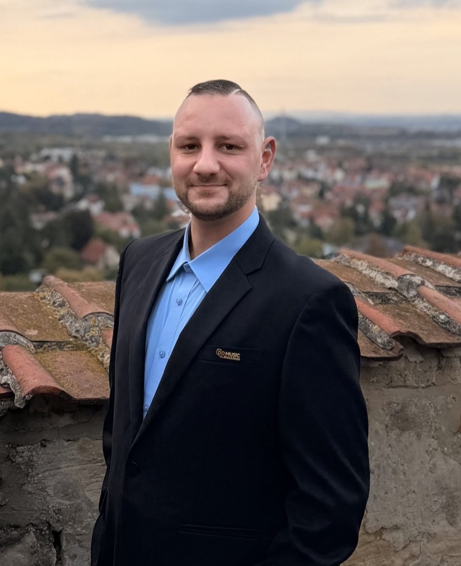DJ Marco Hilse im Anzug über den Dächern von Halberstadt